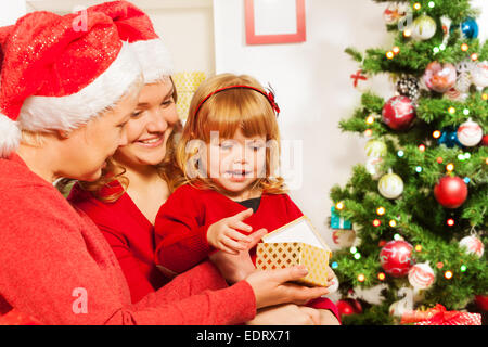 Madre e nonna dando presente a figlia Foto Stock