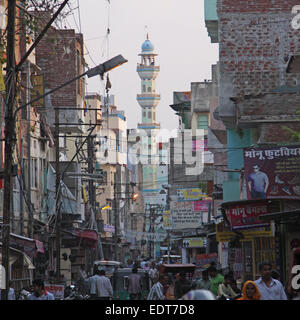 Scena di strada nel cuore della città indiana di Jaipur con minareto in background Foto Stock