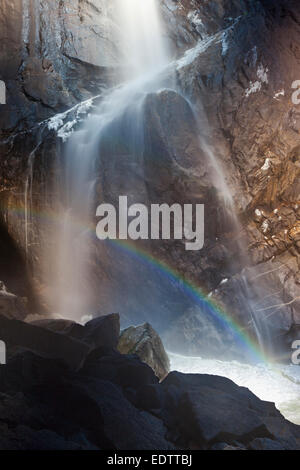 Acqua, arcobaleno e ghiaccio in corrispondenza della base inferiore di Yosemite Falls nel Parco Nazionale di Yosemite Foto Stock