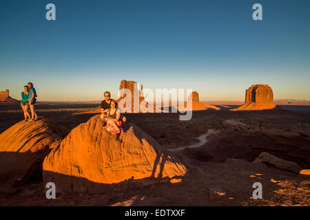 Quattro turisti pongono di fronte i guanti al tramonto nella Monument Valley Foto Stock