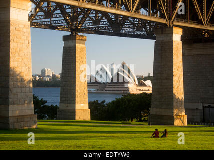 Sydney Opera House e dal porto al tramonto visto attraverso colonne di Harbour Bridge in Bradfield Park Sydney NSW Australia Foto Stock