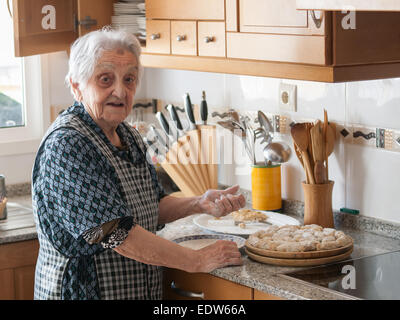 Donna anziana la preparazione di crocchette di purè di patate a casa Foto Stock
