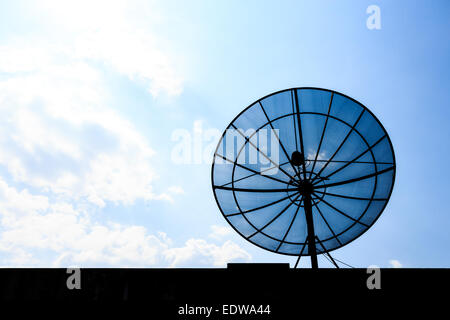 Una parabola satellitare sul tetto e cielo blu nel pomeriggio (Silhouette) Foto Stock