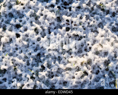 Close up congelate di neve sul terreno con impronte di gocce di acqua, bianco e blu irregolare modello naturale scena invernale in Oslo Norvegia Foto Stock