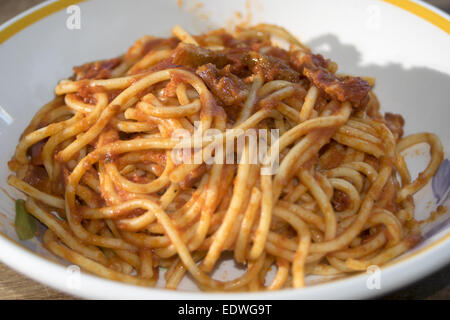 Gustose specialità italiane: spaghetti all'amatriciana o spaghetti con sugo di pomodoro con pancetta Foto Stock