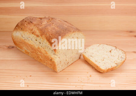 Fetta tagliata da una focaccia appena cotta di avena e semi di lino pane su un tavolo da cucina Foto Stock