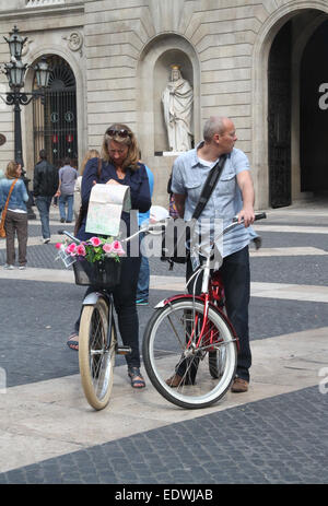 Turista giovane in bici, perse e guardando la mappa in Plaça de Sant Jaume, Barcellona. Foto Stock