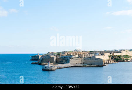 Ricasoli Grand Harbor East frangiflutti e faro rosso Foto Stock