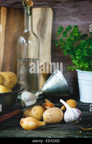 Patate e cipolla e aglio sul vecchio tavolo in legno Foto Stock