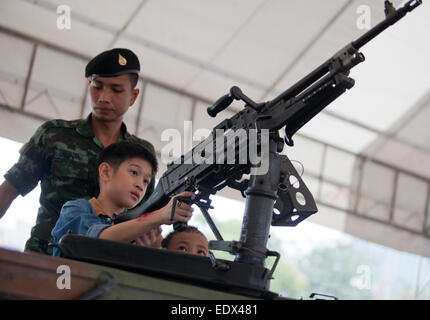 Bangkok, Tailandia. Decimo gen, 2015. I bambini giocano con le armi durante la giornata per i bambini nel principale quartiere espositivo presso la seconda divisione di cavalleria il quartier generale a Sanam Pao, Bangkok in Thailandia il sabato Jan 10, 2015. Credito: PixelPro/Alamy Live News Foto Stock