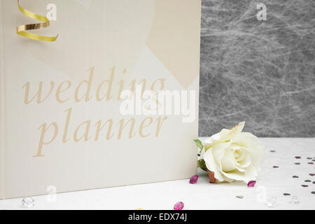 Wedding planner prenota su una tovaglia bianca con nastri d'oro,archi,argento cuore coriandoli e piccolo diamante tabella decorazioni Foto Stock