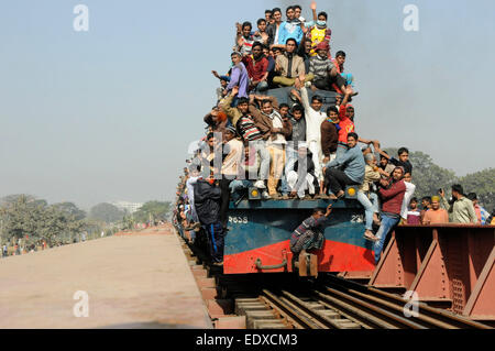 Dacca in Bangladesh. Xi gen, 2015. Pendolari salire sul tetto di un treno come essi partecipare alla preghiera finale cerimonia sulla banca del fiume Turag nella periferia di Dhaka, Bangladesh, 11 genn. 2015. Il Ijtema il luogo e le sue aree adiacenti riverberata domenica pomeriggio con la parola 'Amin' ripetutamente pronunciate da milioni di devoti alzando le mani assieme in Akheri Munajat, preghiera conclusiva della prima fase della seconda più grande musulmano annuale congregazione dopo la santa Hajj. © Shariful Islam/Xinhua/Alamy Live News Foto Stock