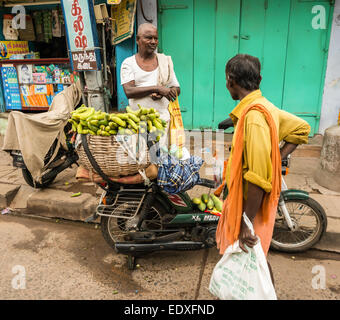 THANJAVOUR, India - 14 febbraio: una persona non identificata sono in piedi presso il motociclo con legumi tropicali. India, Tamil N Foto Stock