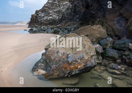 Interessante la geologia nelle rocce a Perranporth beach in Cornovaglia. Vista lungo la lunga spiaggia di sabbia. Foto Stock