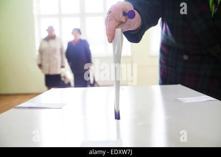 La mano di una persona la fusione di un ballottaggio in corrispondenza di una stazione di polling durante la votazione. Foto Stock