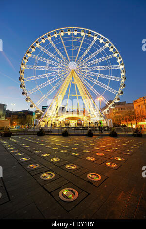 Occhio di Manchester in Piccadilly Gardens illuminata di notte con il colore delle luci cangianti in primo piano dove le fontane sono state. Foto Stock