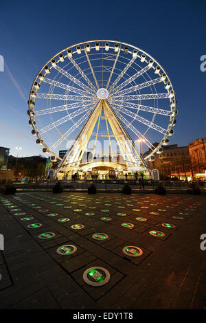 Occhio di Manchester in Piccadilly Gardens illuminata di notte con il colore delle luci cangianti in primo piano dove le fontane sono state. Foto Stock