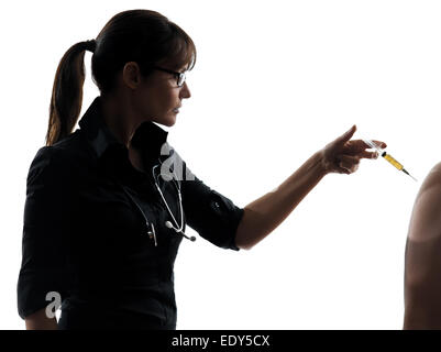 Una donna medico azienda ago chirurgico a vaccinazione silhouette studio isolato su sfondo bianco Foto Stock