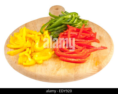 Tagliate a fette il rosso, il verde e il giallo dei peperoni su un tagliere di legno Foto Stock