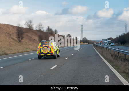 Responsabile del traffico tenendo il traffico per un incidente sulla M56 nel Cheshire Foto Stock