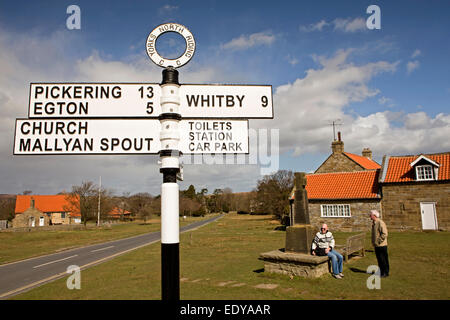 Regno Unito, Inghilterra, Yorkshire, Goathland, cartello stradale e Memoriale di guerra nel centro del villaggio Foto Stock