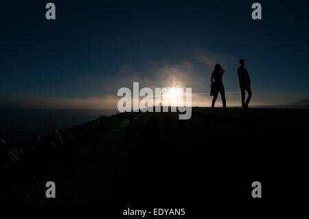 Passeggini sul molo nel tardo pomeriggio sun Foto Stock