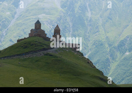 Vecchia chiesa è circondata da montagne. È chiesa Gergeti (Georgia). Foto Stock