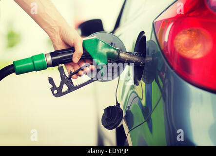 Uomo di pompaggio del carburante benzina in auto alla stazione di gas Foto Stock