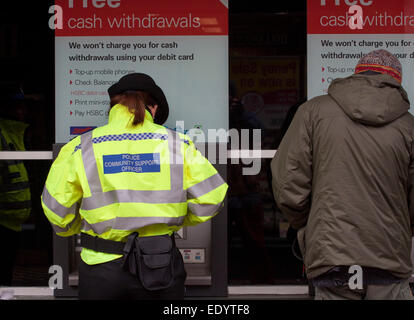 Una donna police community support officer utilizzare un punto di contanti Foto Stock