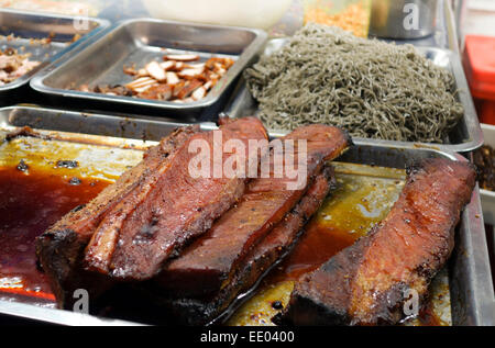Arrosto di maiale in vendita su strada notte mercato intorno MBK shopping center, Bangkok, Thailandia, Sud-est asiatico. Foto Stock