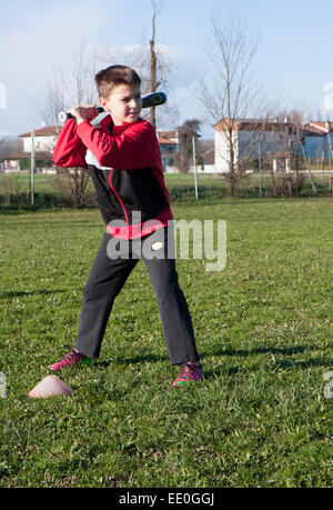 Bambino con plush rosso che gioca a baseball Foto Stock