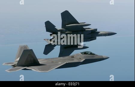 Un caccia F-15 Eagle esegue una manovra sulla riva sinistra mentre vola in formazione con un F/A-22 Raptor vicino alla costa della Virginia. Questa operazione fa parte di un'esercitazione addestrativa del 27th Fighter Squadron con due Raptor in prestito dalla Tyndall Air Force base. Foto Stock