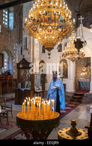 Chiesa Greco Ortodossa interno con sacerdote nel villaggio di Exohori, uomo esterno, Peloponneso e Grecia. Foto Stock