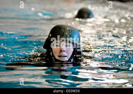 US Army Officer candidato Wendy McDougall nuota indossando di combattimento completa e uniforme casco durante l'acqua di formazione di sopravvivenza Gennaio 10, 2015 in Rehoboth Beach, Delaware. Foto Stock