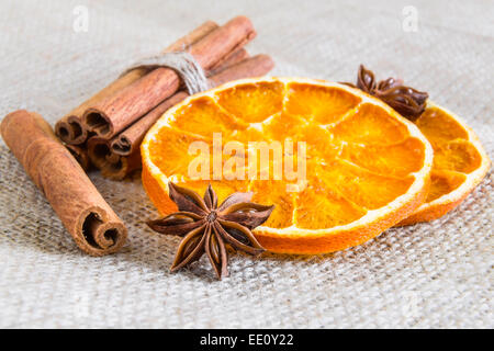 Stelle di anice, cassia bastoncini di cannella ed essiccato anelli arancioni su tela Foto Stock
