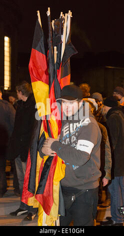 05/01/2015. Colonia, Germania. Un diritto-wing protester frizioni tedesco bandiere nazionali prima di consegnarle a sostenitori. Circa duecento a destra i manifestanti a seguito di una chiamata a demonstate contro l islamizzazione dell' Europa a Colonia, in Germania. Il KÖGIDA dimostranti sono stati di gran lunga numericamente sopraffatta dalle migliaia di sinistra-ala contestatori. Questo segue il PEGIDA dimostrazioni di Dresda che mantenere attrarre un gran numero di seguaci. PEGIDA sta per "Unione patriottica contro l islamizzazione dell'Europa". Come una manifestazione di protesta, Cattedrale di Colonia - di solito illuminata di notte - rimane buio in segno di protesta ag Foto Stock