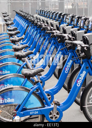 Una doppia fila di citibike noleggio biciclette sotto la pioggia. Una lunga fila di biciclette a noleggio gocciolamento sotto la pioggia vicino al terminale del traghetto. Foto Stock