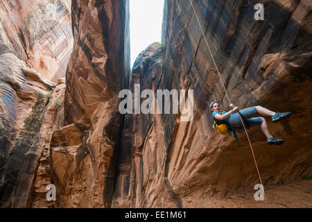 Donna rapelling giù un arco gigante, canyoning, Moab, Utah, Stati Uniti d'America, America del Nord Foto Stock
