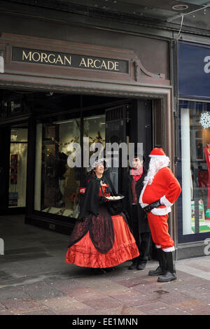 Padre Natale chattando a persone in costumi vittoriani al di fuori della Morgan Arcade nel centro di Cardiff. Foto Stock