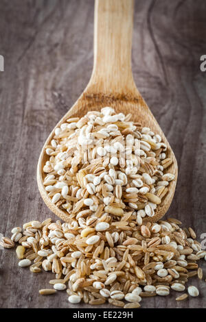 Mescolati i cereali grezzi su un cucchiaio di legno Foto Stock