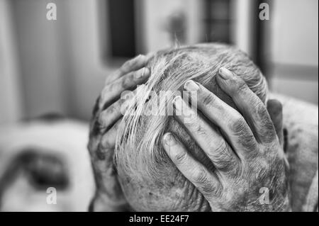 Tenendo la testa quelli nel profondo anche se preoccupante e contemplando la tristezza e la felicità dei tempi precedenti memorie di un titolare di pensione o di rendita Foto Stock