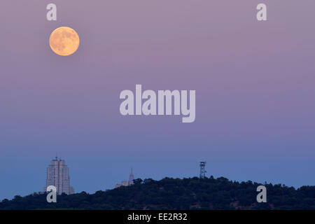 La luna piena appare al suo incontro più vicino con la terra come sorge oltre la skyline di Madrid Foto Stock