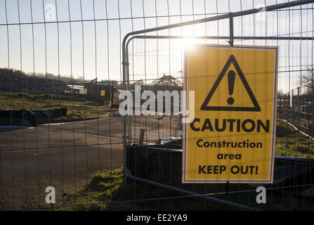Un 'attenzione area di costruzione. Tenere fuori!' firmare in un recinto in una casa sito di costruzione in Watchfield, Oxfordshire, Regno Unito Foto Stock