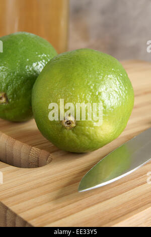 Verde lime persiano su di un tagliere in attesa di essere affettato per bevande o per la cottura Foto Stock