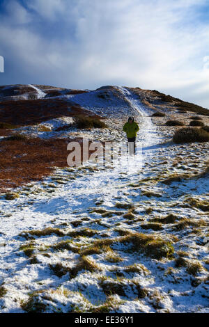 Un lone hillwalker camminando lungo il Offas Dyke percorso fino verso il sumit di Pennycloddiau Hillfort parte della gamma Clwydian hills nel Galles del Nord. Foto Stock