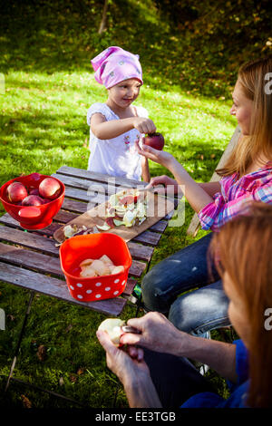 Donne sbucciare le mele in giardino, Monaco di Baviera, Germania Foto Stock