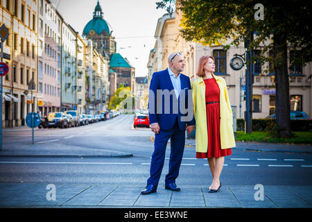 Coppia senior tenendo le mani sulla via della città di Monaco di Baviera, Germania Foto Stock