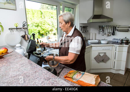 Le donne anziane, Senior, metà 70, cuochi a casa in cucina, caffè, Foto Stock