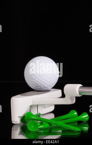 Golf putter e diverse attrezzature da golf sul vetro nero scrivania Foto Stock