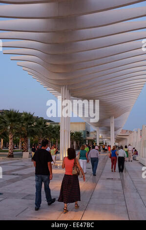 Malaga, Spagna; la gente fuori a piedi lungo il moderno lungomare di Malaga in serata Foto Stock